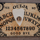 An Ouija board, the viewed from above, the pointer resting over the T.